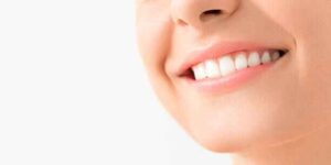 Woman smiling with white teeth, preparing for oil pulling for coconut oil