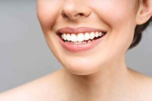 A person with a healthy, bright smile achieved through safe dental practices.
