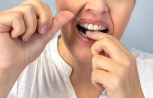 Correct flossing technique to remove plaque between teeth naturally